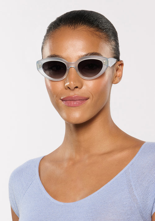IRENE | Handcrafted, luxury powder blue acetate medium sized upswept oval wrap KREWE sunglasses womens model | Model: Sasha