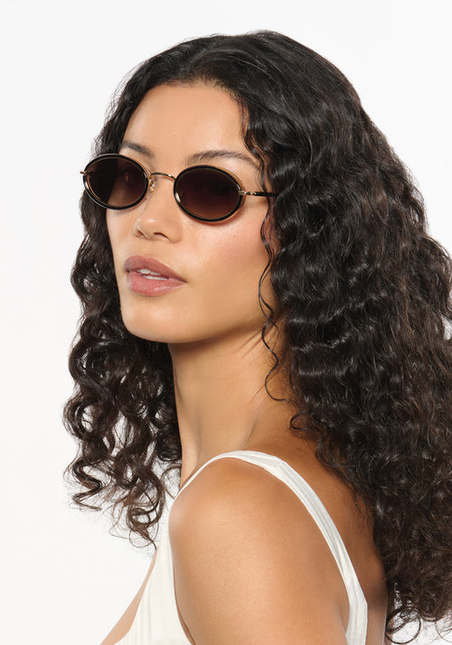 KATE | 12K + Black Tea Handcrafted, luxury black acetate and stainless steel small oval KREWE sunglasses womens model | Model: Jessika