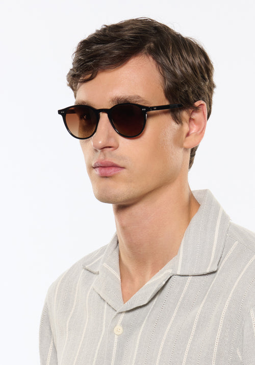 LANDRY | Black + Black Tea Handcrafted, luxury black acetate round KREWE sunglasses mens model | Model: Jegor