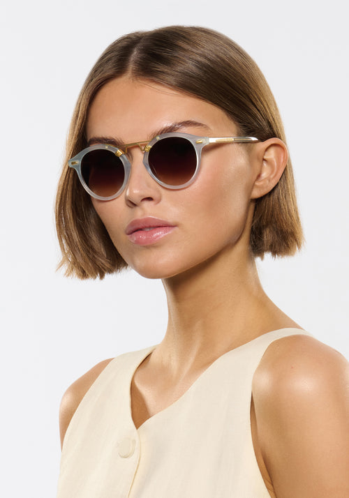 ST. LOUIS | Powder Blue 18K Handcrafted, luxury, light blue acetate round KREWE sunglasses with gold bridge and hardware womens model | Model: Michelle