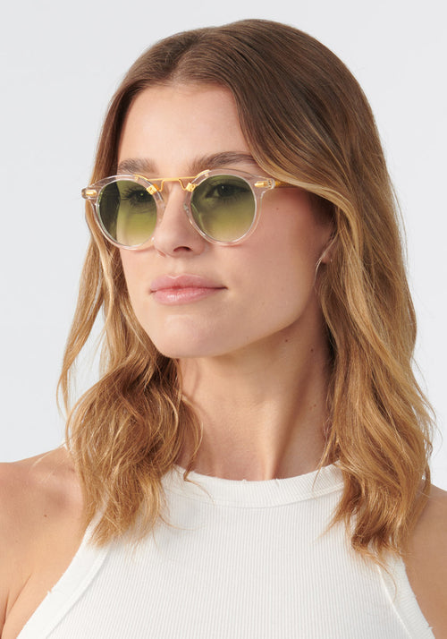 KREWE SUNGLASSES - ST. LOUIS MIRRORED | Crystal 24K + Custom Vanity Tint handcrafted, luxury round clear sunglasses with a double metal bridge and green tinted lenses womens model | Model: Keke