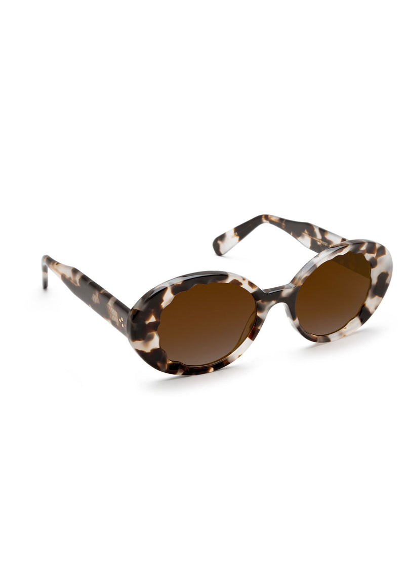 Tortoiseshell oval sunglasses with brown gradient lenses and patterned acetate frames.