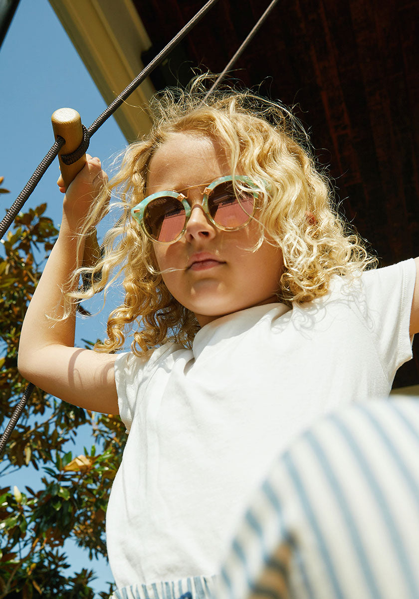 KREWE - ST. LOUIS KIDS | Seaglass to Marine Rose Gold Mirrored handcrafted, luxury blue and pink sunglasses made for children. Featuring krewe's iconic double metal bridge womens model | Model: Cecilia