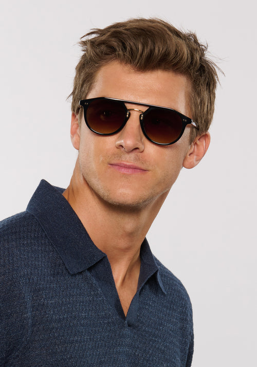MARKLE | Black + Black Tea 18K Handcrafted, luxury black acetate medium round KREWE sunglasses with gold stainless steel metal hardware mens model | Model: Ben