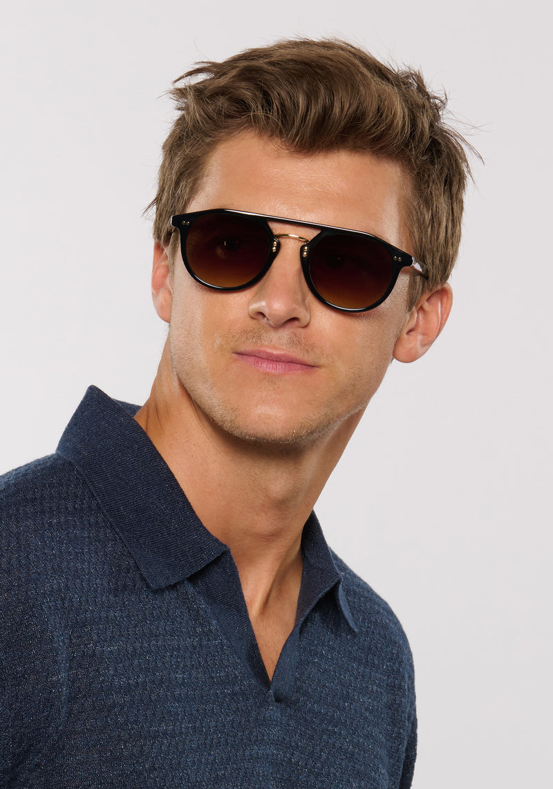 MARKLE | Black + Black Tea 18K Handcrafted, luxury black acetate medium round KREWE sunglasses with gold stainless steel metal hardware mens model | Model: Ben
