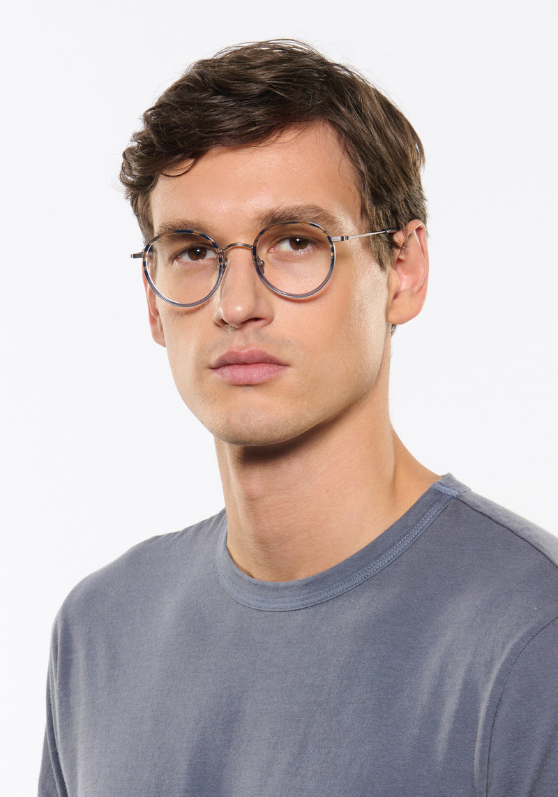 MAYFAIR | Matte Raw Titanium + Rhodes Handcrafted, luxury navy grey acetate and titanium round KREWE eyeglasses mens model | Model: Jegor