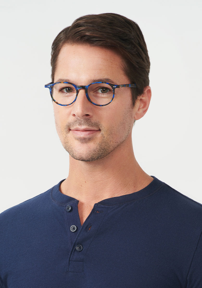 CARSON II | Matte Blue Steel Handcrafted, luxury blue tortoise round KREWE eyeglasses mens model | Model: Andrew