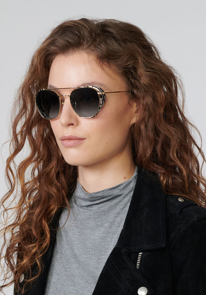 EARHART BLINKER | Matte Black + 24K Domino Handcrafted, luxury black and white spotted acetate KREWE sunglasses womens model | Model: Helouise